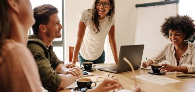 Group of multi ethnic executives discussing during a meeting. Business man and woman sitting around table at office and smiling.